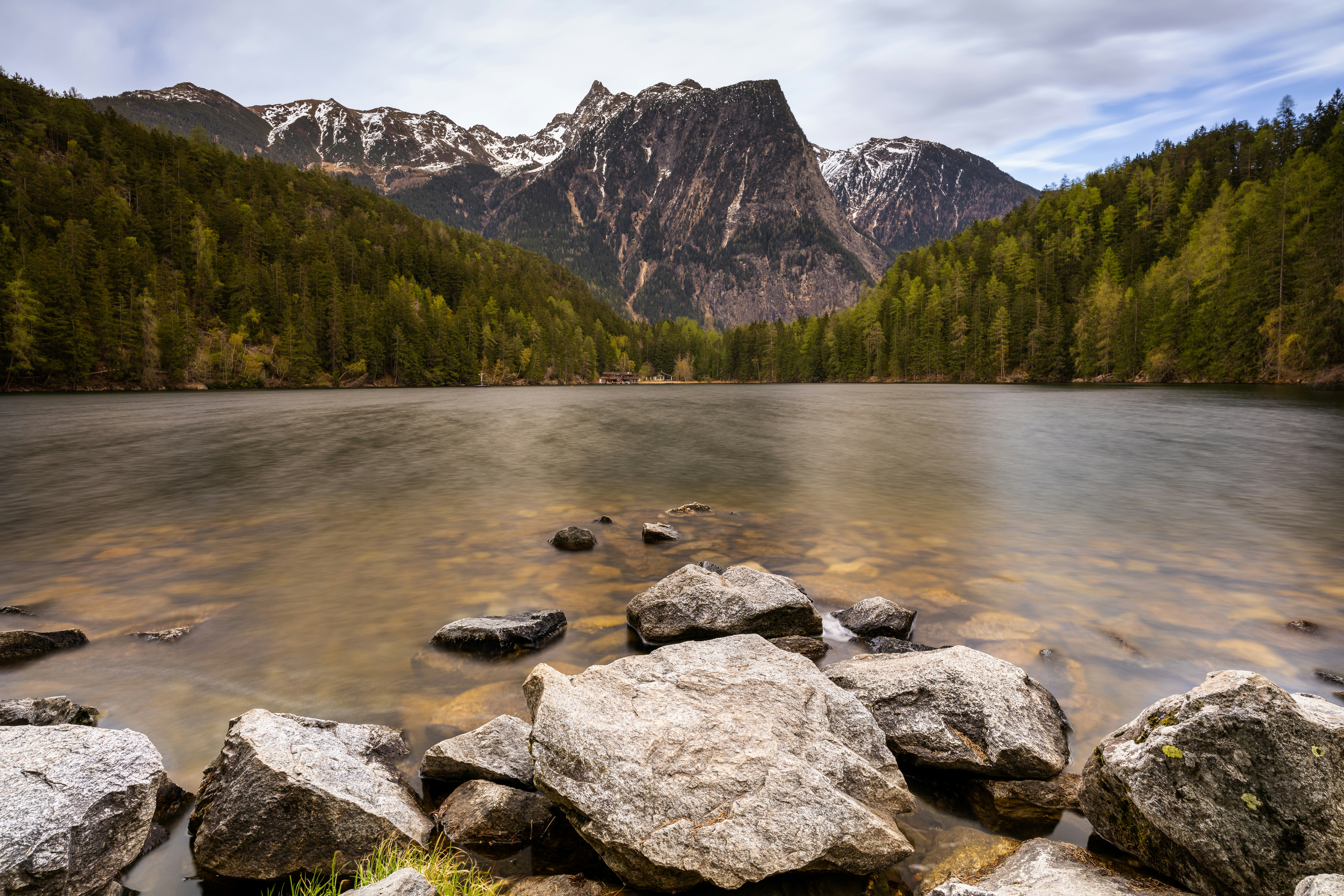 Un lago con rocas y montañas al fondo foto – Imagen de Mar gratuita en  Unsplash, image size:3000x2000