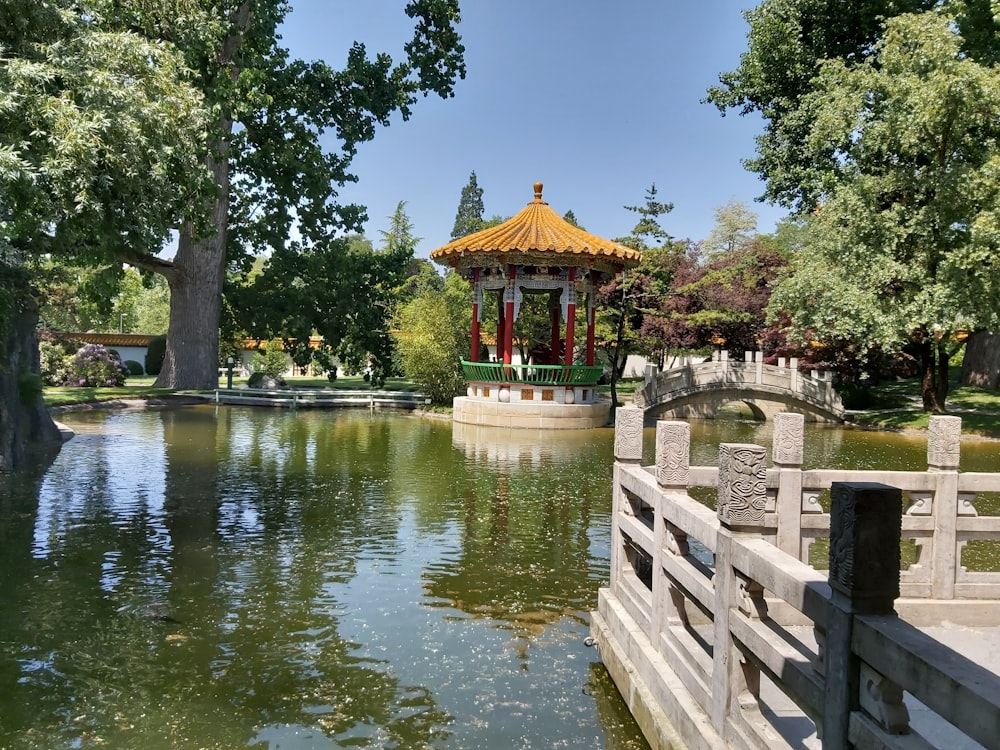 a wooden bridge over a body of water with a pagoda in the background