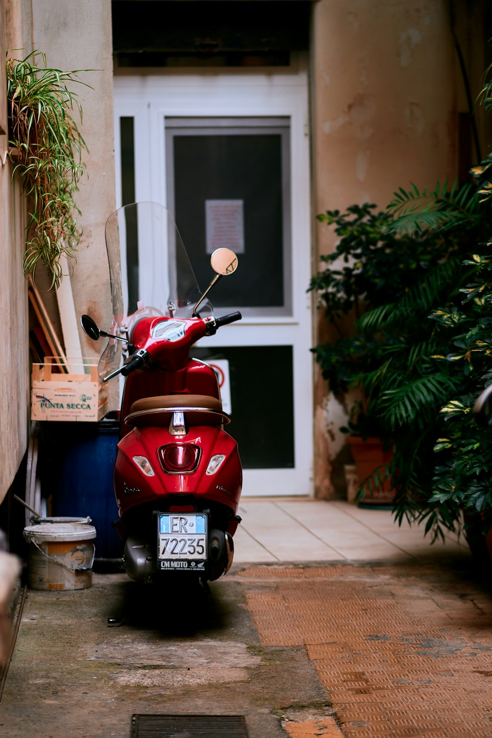 a red scooter parked outside a house