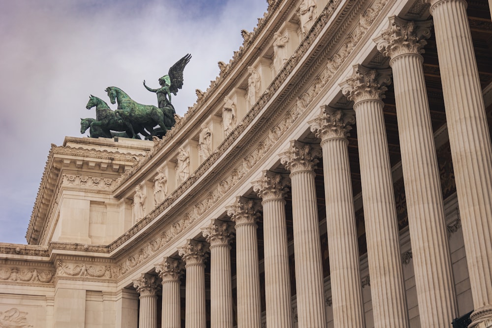 une statue d’une personne sur un cheval devant un bâtiment