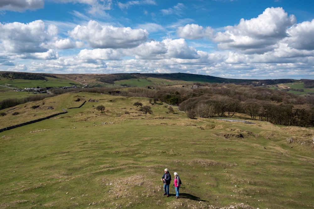 a group of people walking on a grassy hill