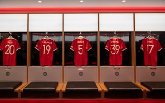a group of red shirts in a room with benches