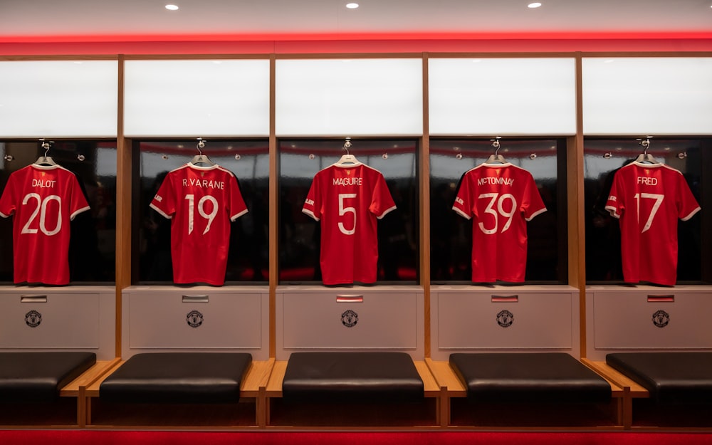 a group of red shirts in a room with benches