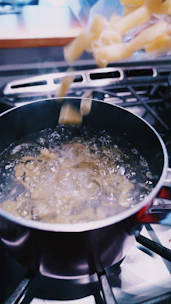 A warm kitchen scene showing a hand pouring boiling water into a Zede instant meal pouch.