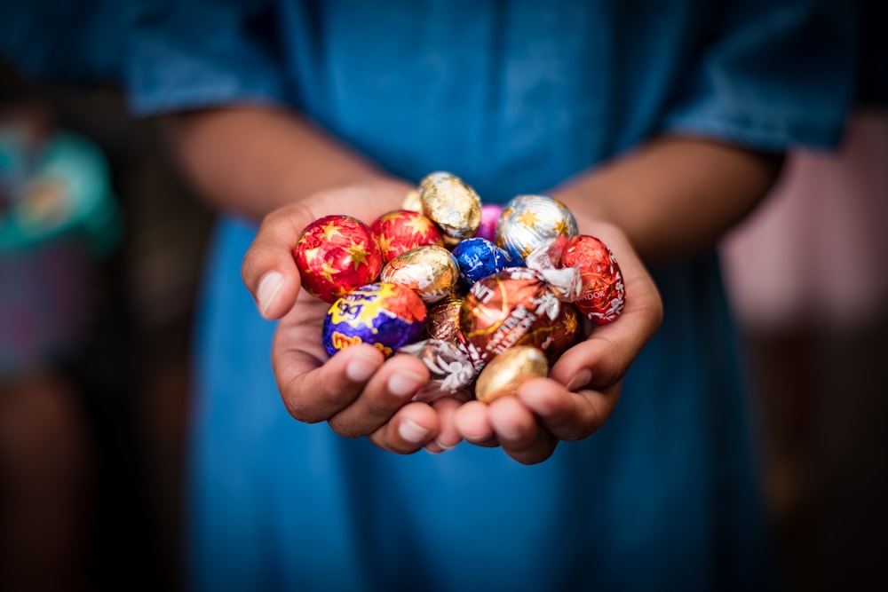 a person holding a bowl of candy