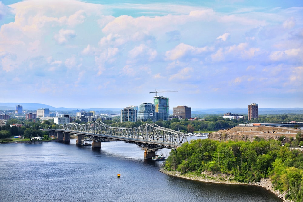 a bridge over a river with a city in the background