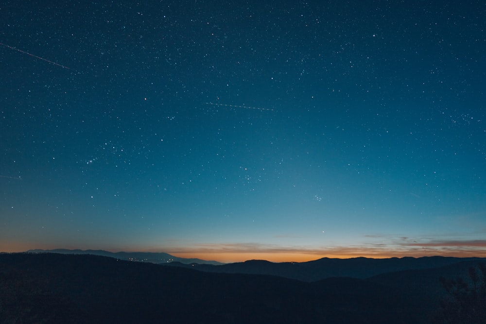 Un cielo notturno stellato sopra una catena montuosa