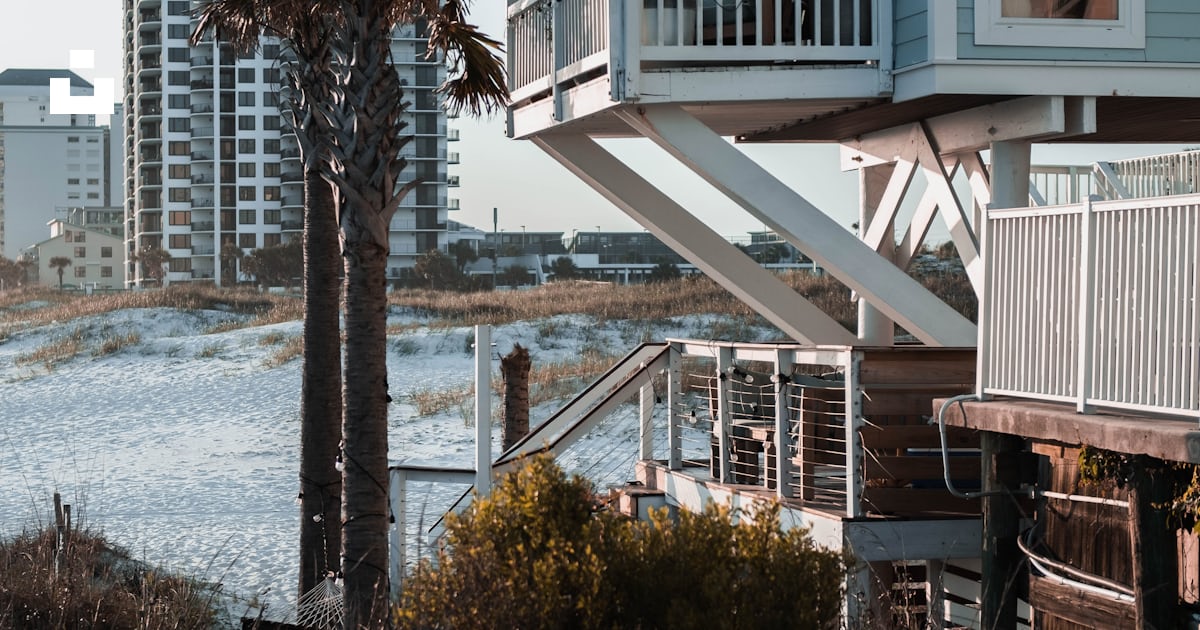 A house with a deck and trees by the water photo – Free Panama city