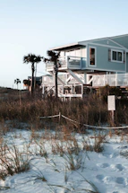 Elegant coastal home with soft neutral tones and a sunlit porch overlooking the beach.