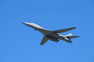 A sleek aircraft soaring against a clear blue sky.