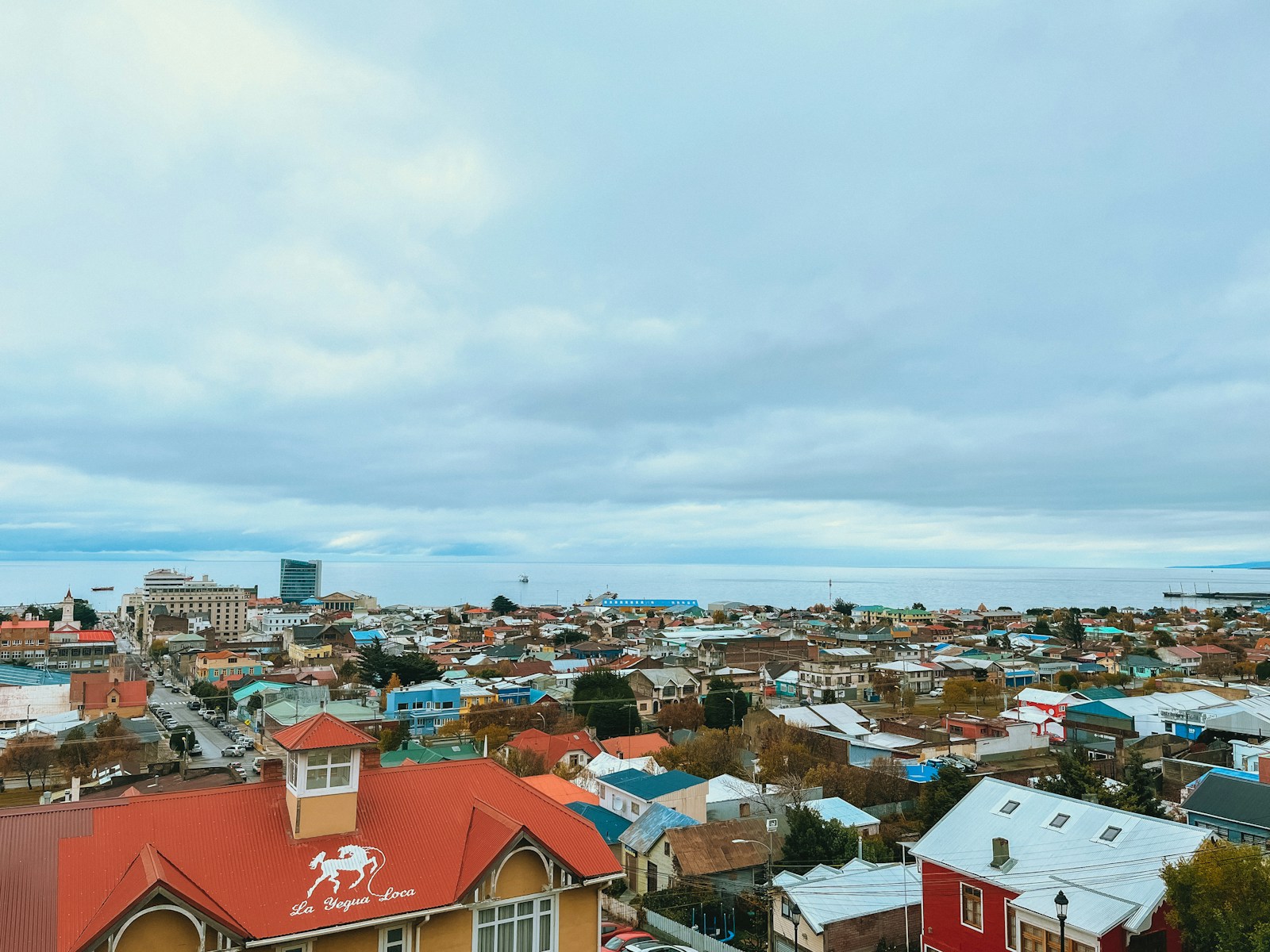 A view over the colourful rooftops of Punta Arenas towards the grey water of the Strait of Magellan