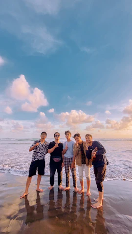 A vibrant group photo of the five Sunwave Radio presenters smiling warmly against the backdrop of Eastbourne’s seafront.