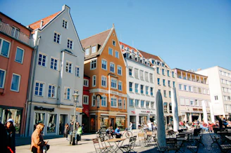 A lively European city square with historic buildings and outdoor cafes.