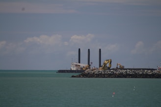 Construction of a jetty extending into calm coastal waters.