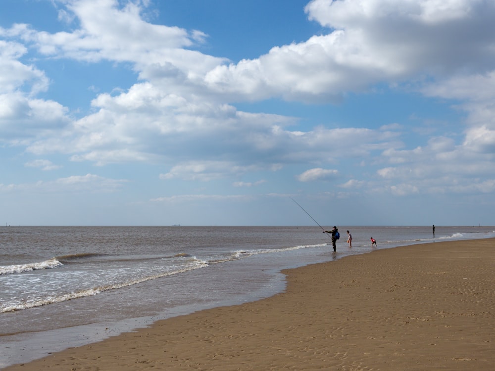 people on a beach with Camber Sands in the background
