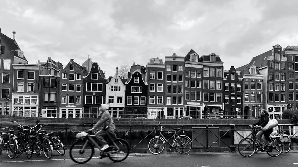 a group of people ride bikes down a street