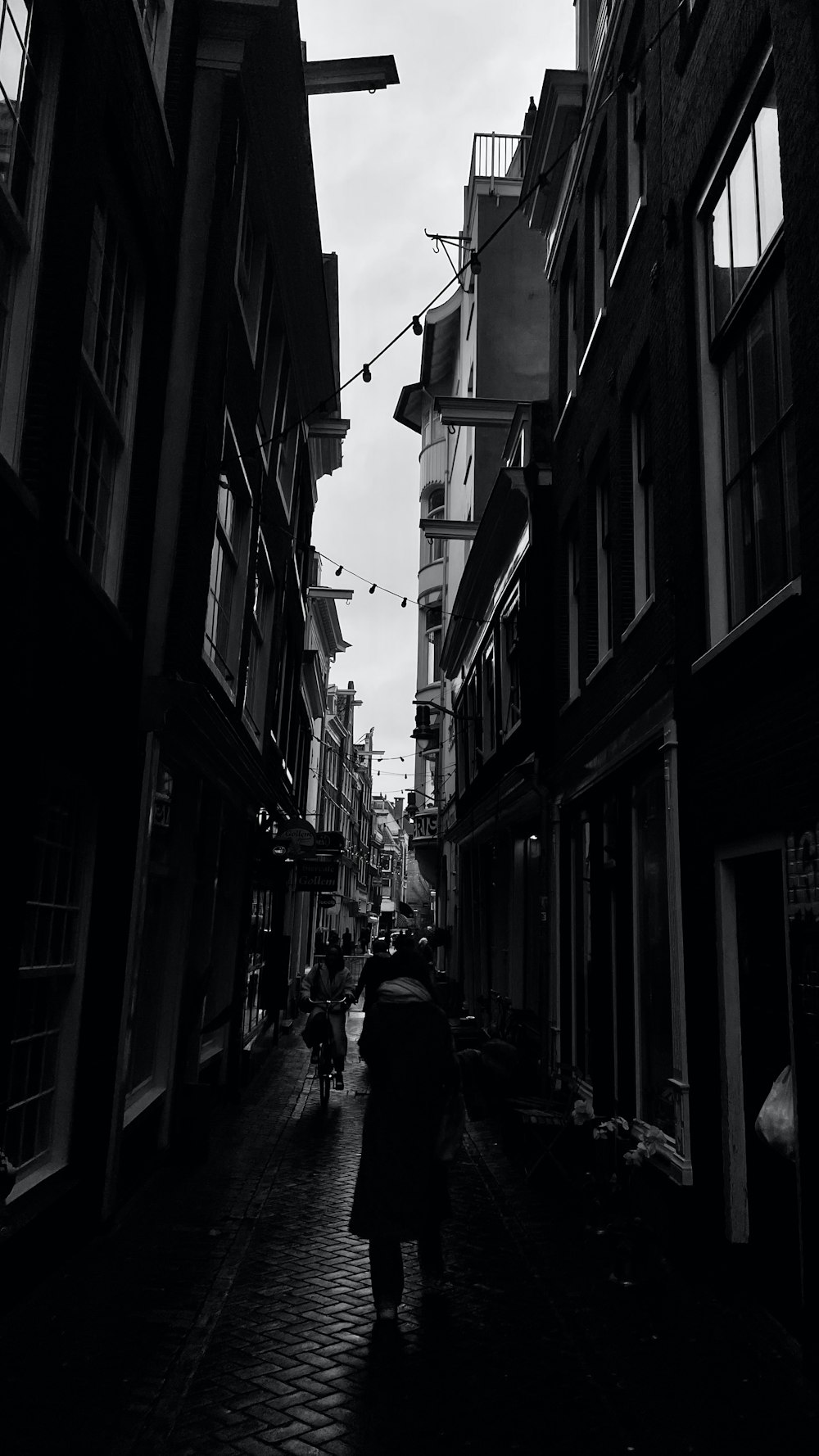 a person walking down a street between buildings