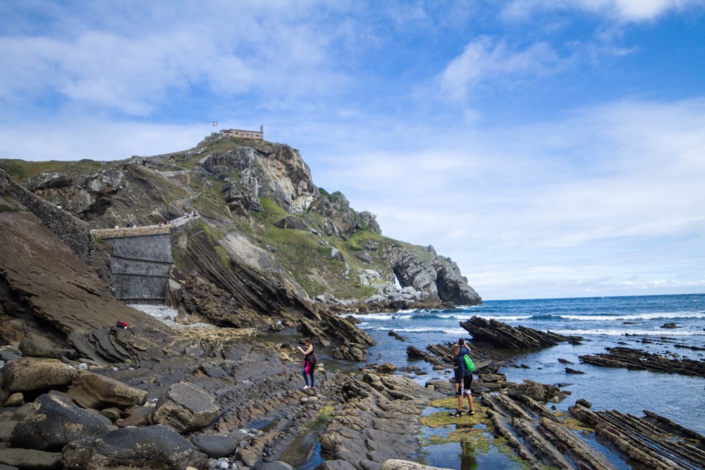 people walking on a rocky beach