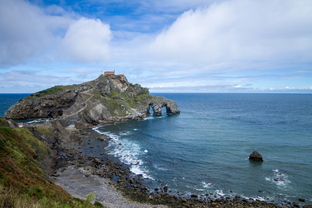 a rocky cliff next to a body of water