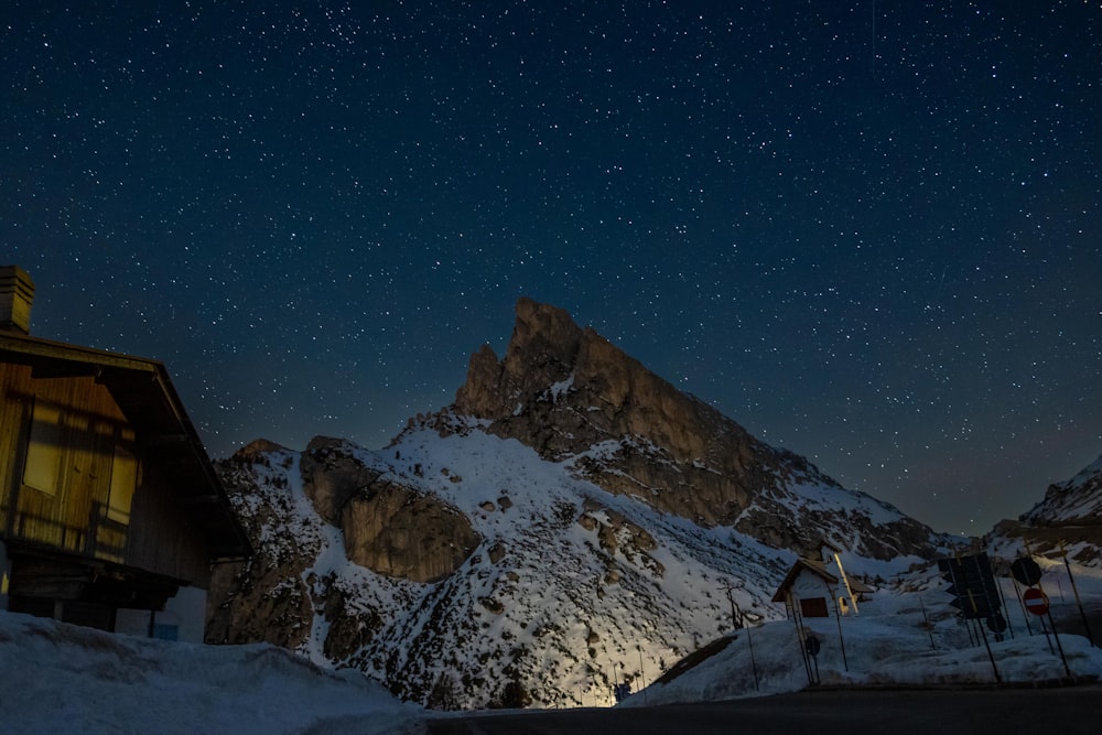 a snowy mountain with a building and a starry sky