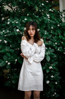 a woman posing in front of a bush