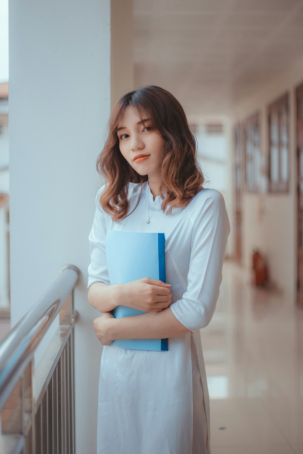 a woman holding a blue book