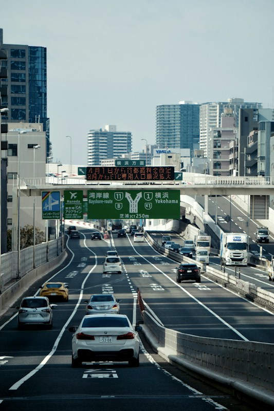 日本都市高速公路上方的綠底出口指示門架與資訊看板