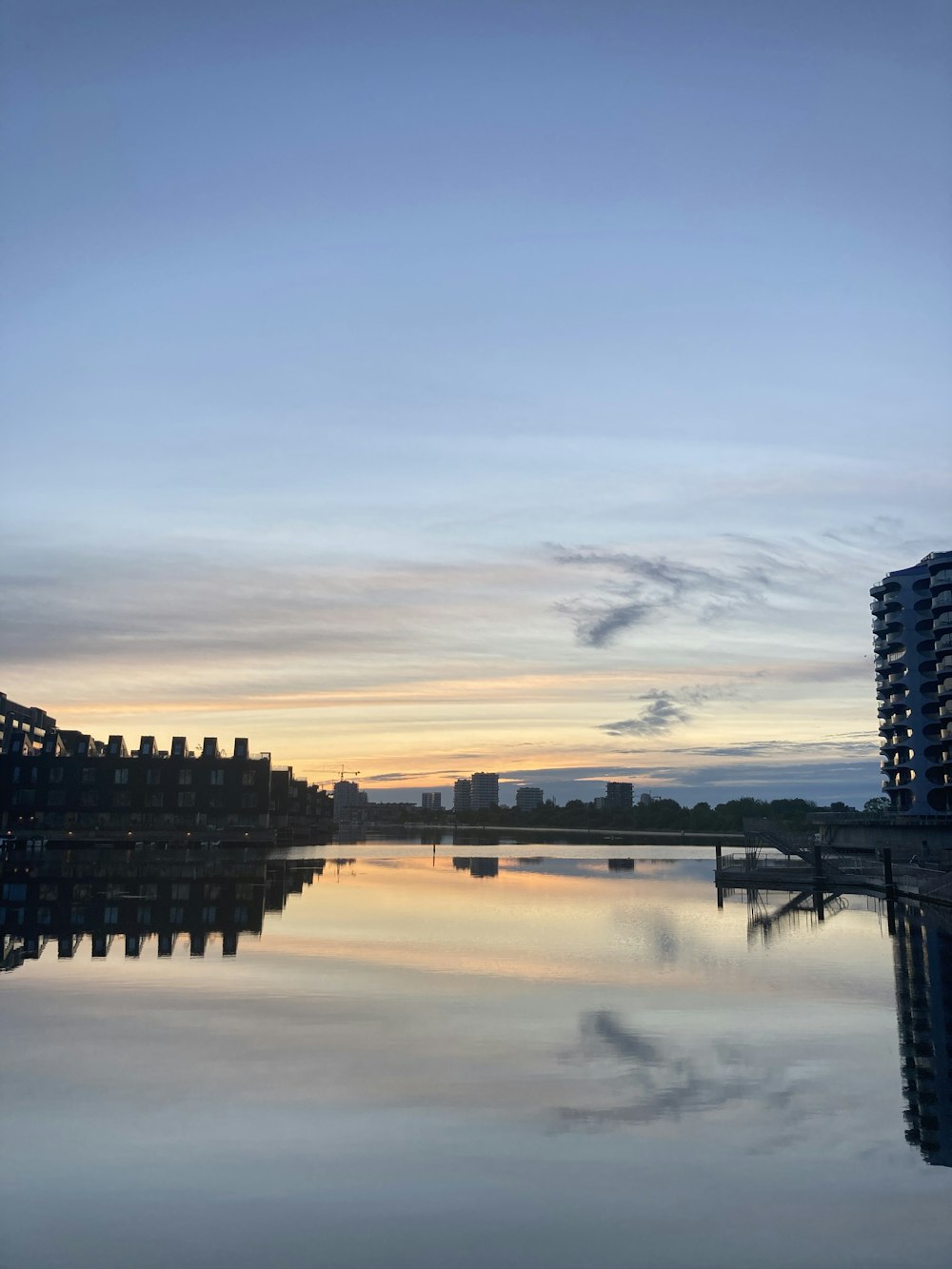 a body of water with buildings and a bridge in the background