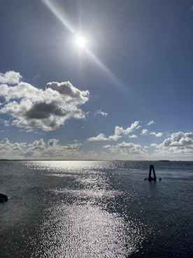 a body of water with a boat in it and a blue sky above