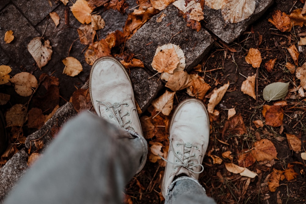 a person's feet in a pile of leaves