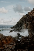 Waves crashing along the rocky Skeleton Coast with a dramatic cloudy sky.