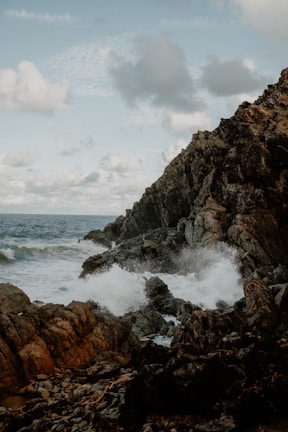 Waves crashing along the rocky Skeleton Coast with a dramatic cloudy sky.