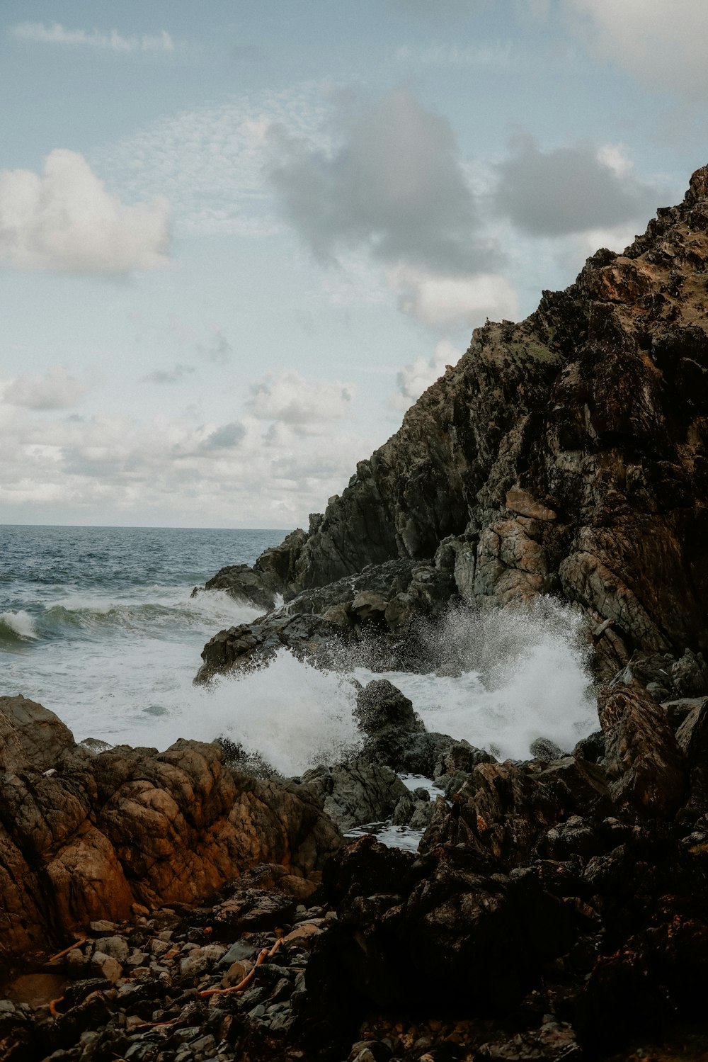 a rocky cliff with waves crashing against it