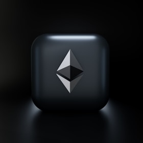 A sleek, modern design featuring a three-dimensional geometric shape resembling the Ethereum logo, centered on a glossy dark gray square with subtle lighting effects. The background fades into a deep black, highlighting the central emblem.