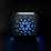 A digital, stylized design featuring a square-shaped object with rounded edges, displaying a symmetric arrangement of various-sized blue circles on its surface, set against a dark background.