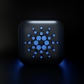 A digital, stylized design featuring a square-shaped object with rounded edges, displaying a symmetric arrangement of various-sized blue circles on its surface, set against a dark background.