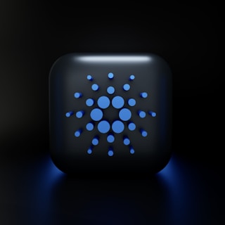 A digital, stylized design featuring a square-shaped object with rounded edges, displaying a symmetric arrangement of various-sized blue circles on its surface, set against a dark background.