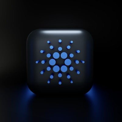 A digital, stylized design featuring a square-shaped object with rounded edges, displaying a symmetric arrangement of various-sized blue circles on its surface, set against a dark background.