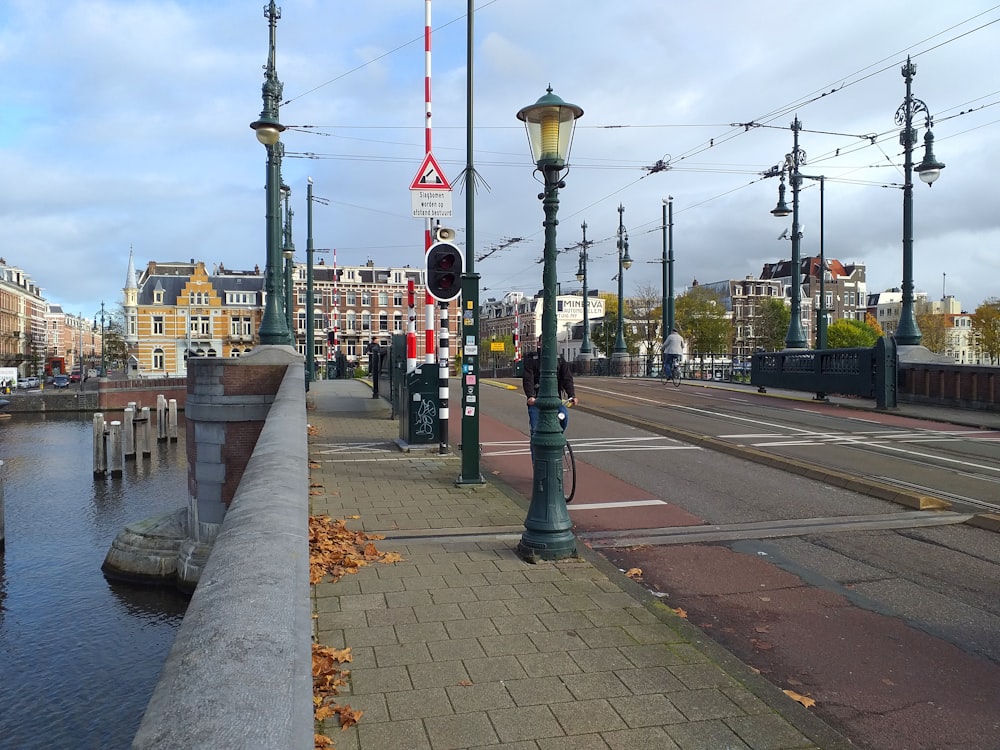 a street with a lamp post and a body of water