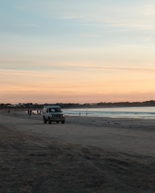 Sunset view of a private transfer vehicle driving along a coastal road near Búzios.