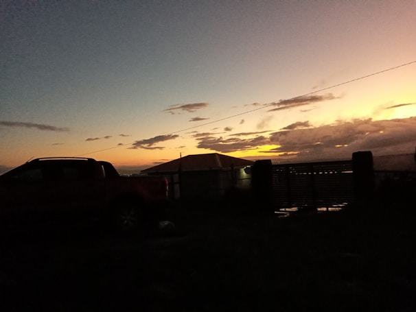 Ron West Roofing truck parked outside a residential neighborhood at sunset.