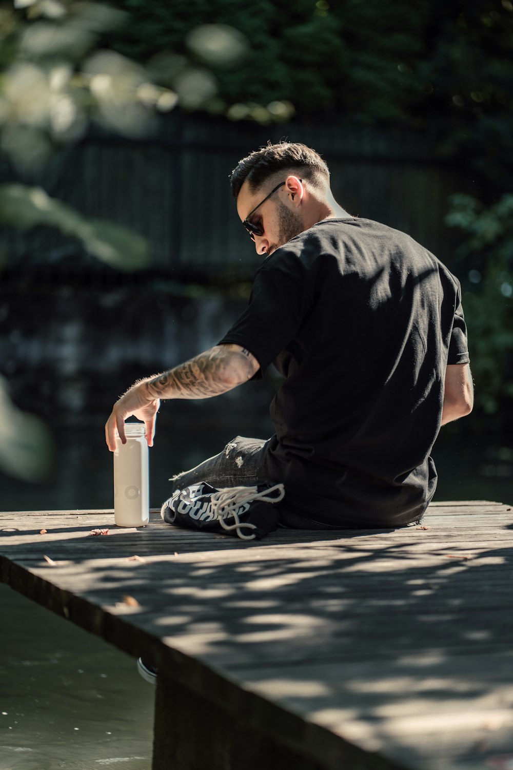 a man squatting down holding a can and a bottle