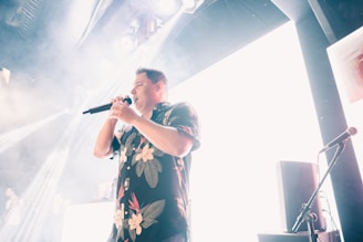 Mr. Lee G performing passionately on stage under vibrant lights.