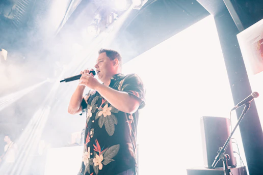 Close-up of p-pain passionately performing on stage with a vintage microphone.