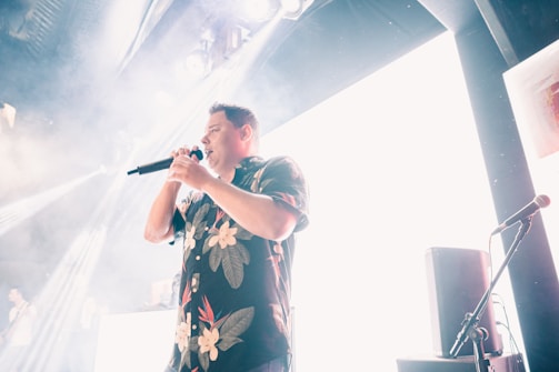 Mr. Lee G performing passionately on stage under vibrant lights.