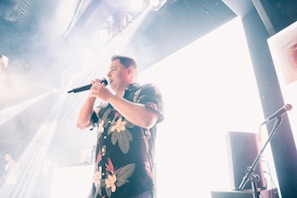 Willy Bula performing passionately on stage with vibrant lighting