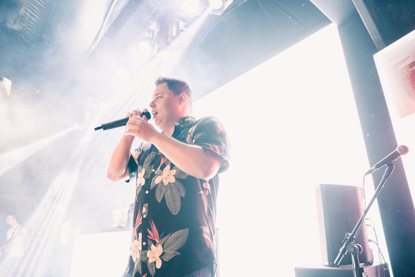 Willy Bula performing passionately on stage with vibrant lighting.