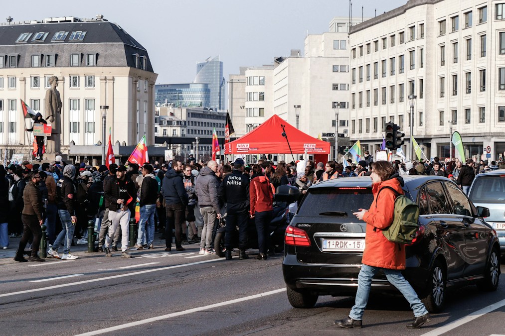 Rassemblement syndical avec drapeaux rouges et tente rouge sur un boulevard bruxellois, image de la manifestation nationale du 9 octobre 2026