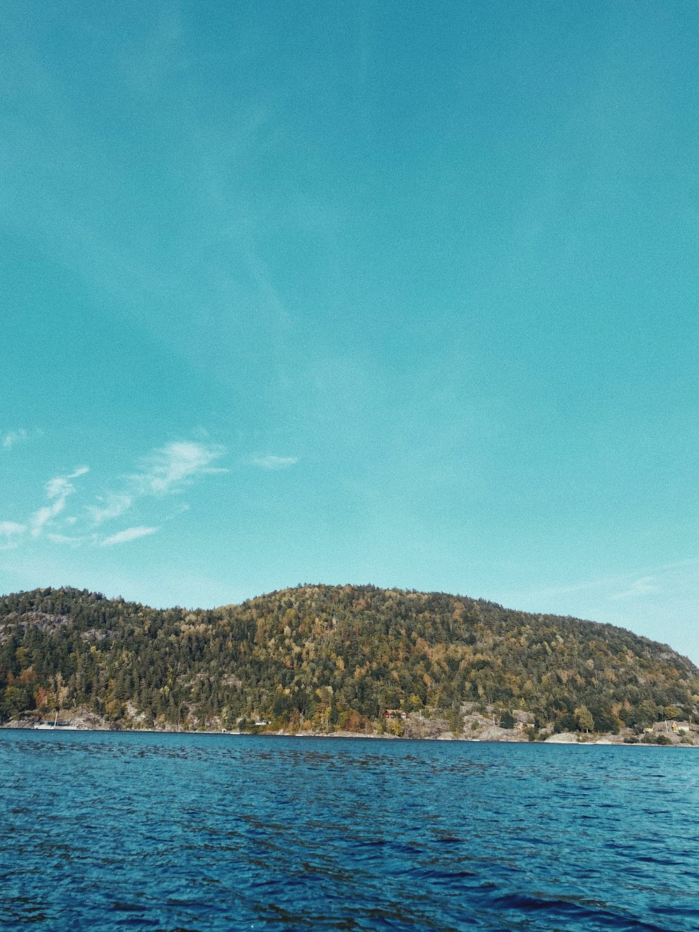 a body of water with a hill in the background