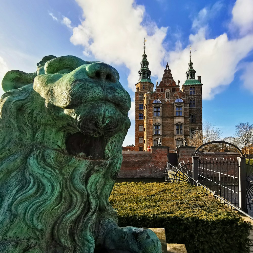 a statue of a lion in front of a castle